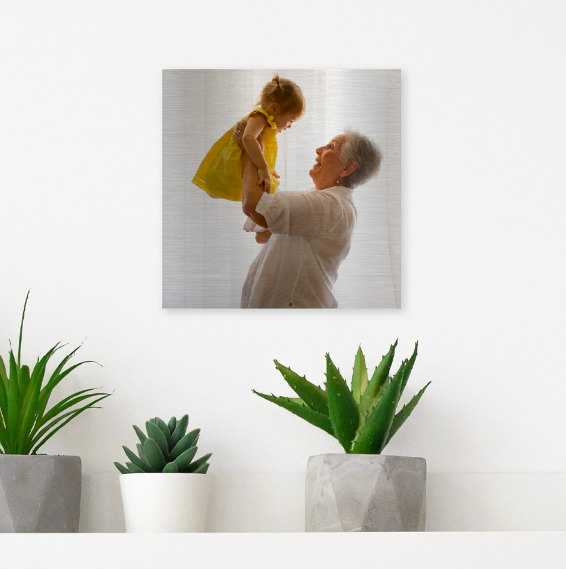 200x200mm brushed silver aluminium print with photo of grandmother holding grandchild indoors