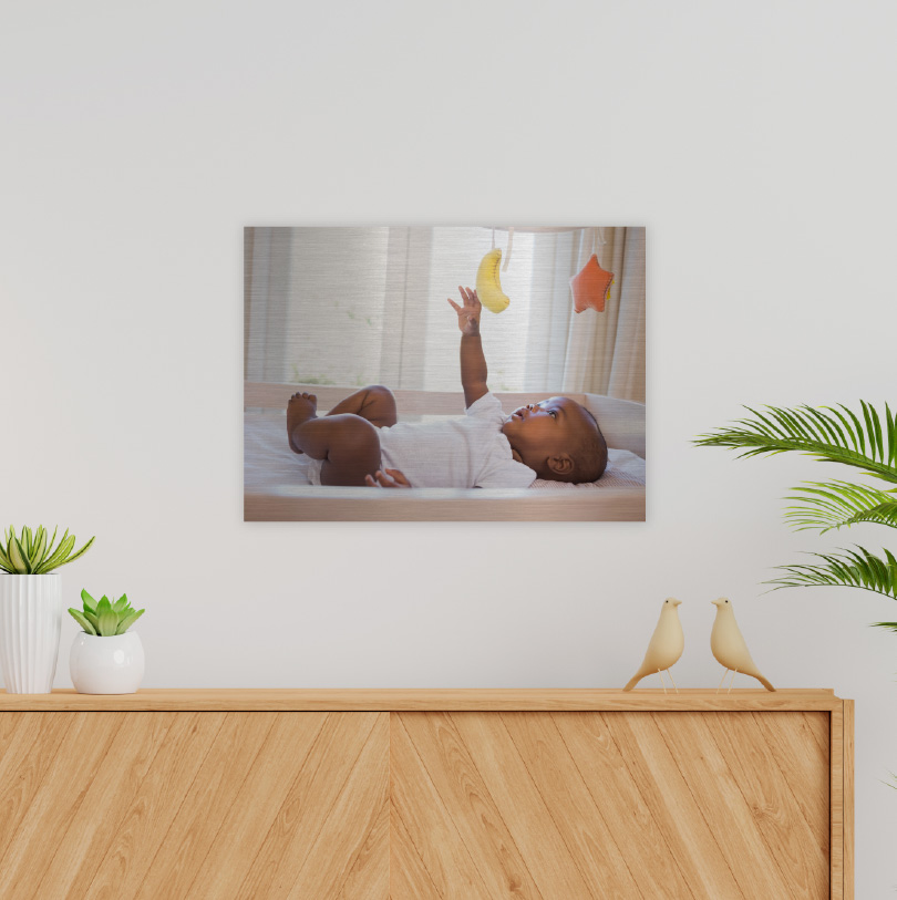 300x400mm brushed silver aluminium print with photo of baby playing with toys indoors happily