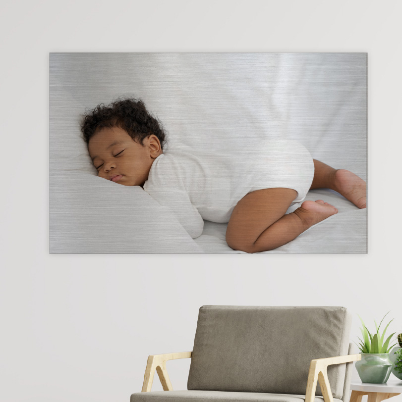 600x800mm brushed silver aluminium print with photo of baby sleeping peacefully indoors
