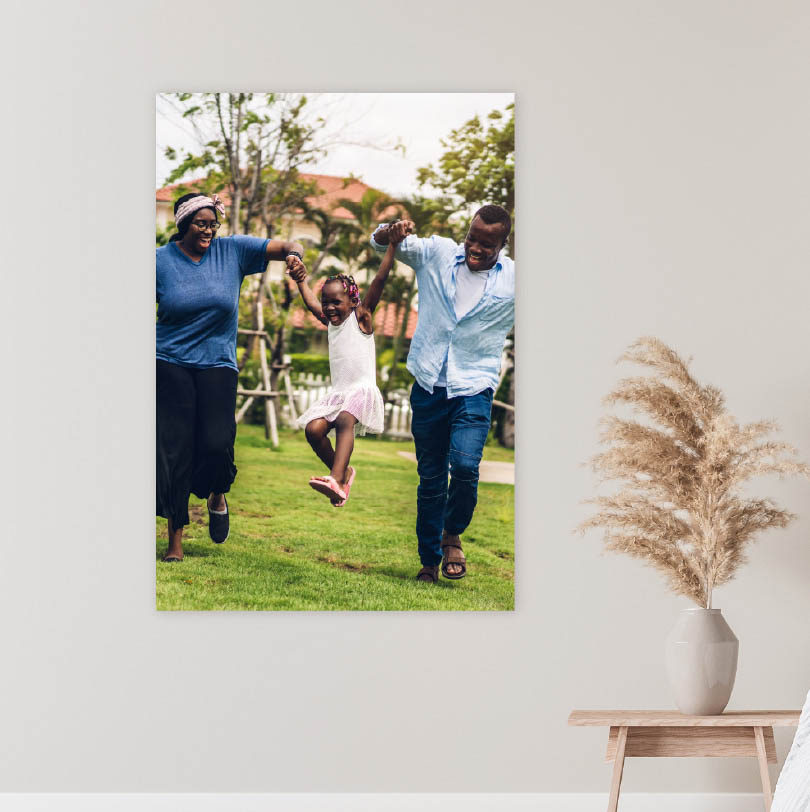 700x500mm foam board print with photo of mother and father swinging daughter between them outdoors smiling and playing