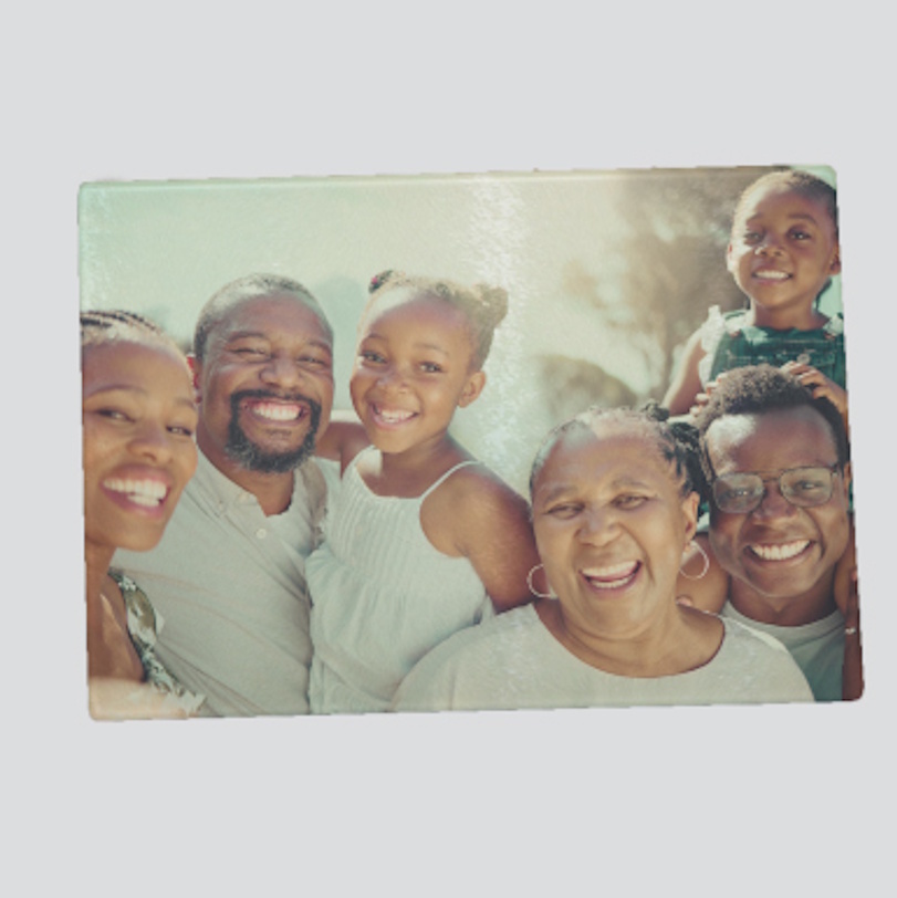 Glass cutting board printed with a photo of a smiling family together.