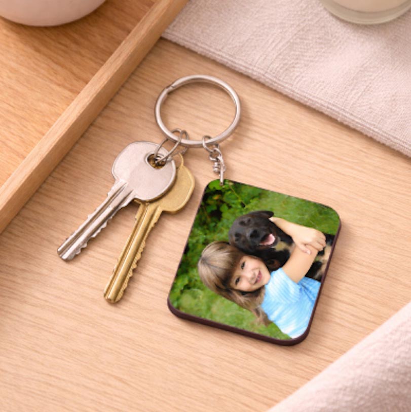 Set of 2 key rings printed with a photo of a little girl holding her dog.