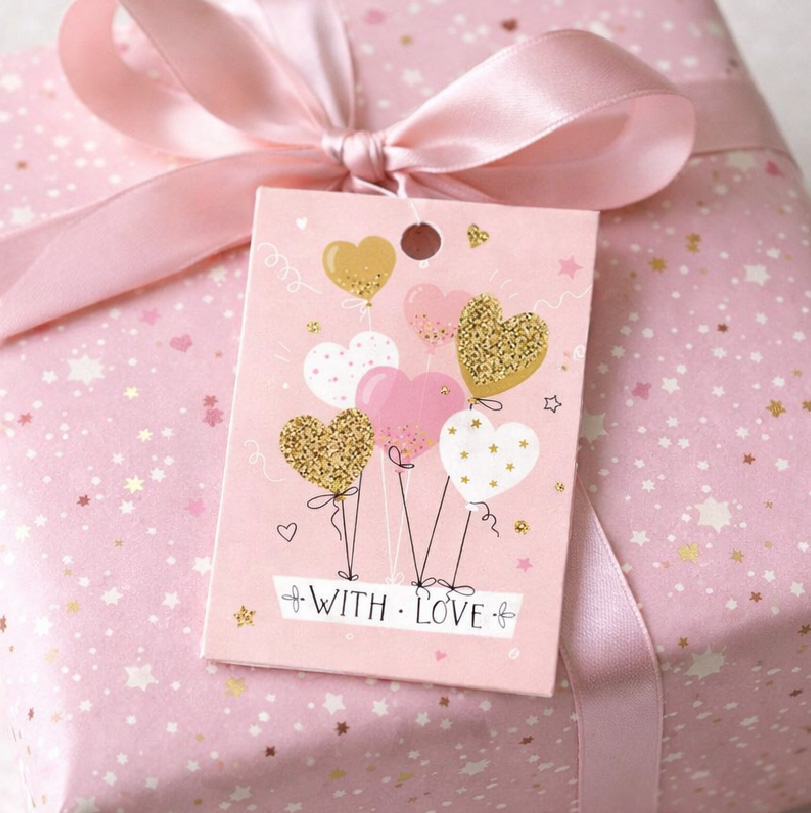 Birthday gift tags attached to a wrapped present for birthday celebration gifting