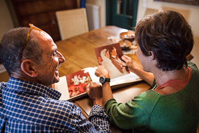 Elderly Couple Creating a Personalised Photobook Together Elderly couple designing a custom photobook with personal photos and memories