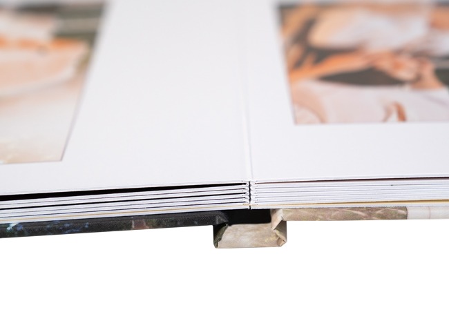 Close-up of lay flat photobook binding showing seamless spine construction for full-page panoramic photo spreads.