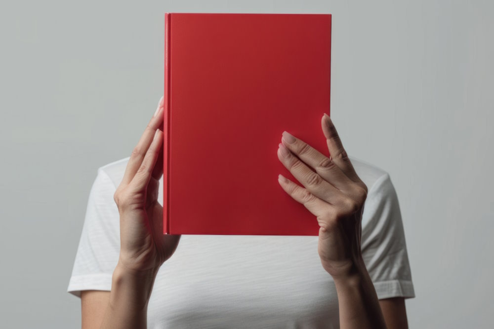 Man Holding Portrait Hardcover Photobook Man holding a portrait orientation hardcover photobook with printed photo pages inside.