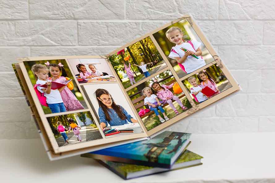 Open photobook showing children’s activities and family moments captured in printed photos.
