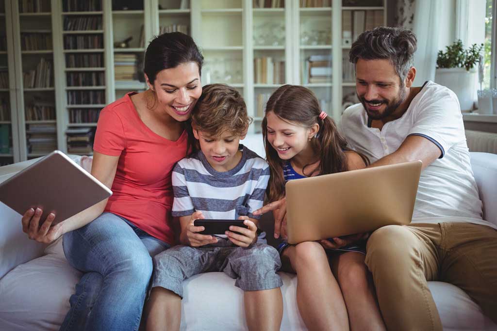 Parents and children working together on a personalised photobook with family photos