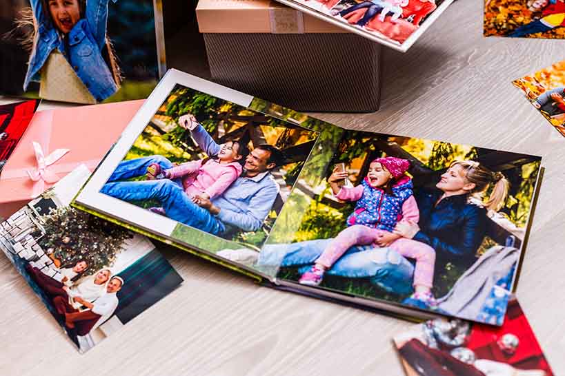 Photobook and Printed Photos on Table | Preserving Memories Photobook with printed photos arranged on a table, displaying special memories and photo keepsakes.