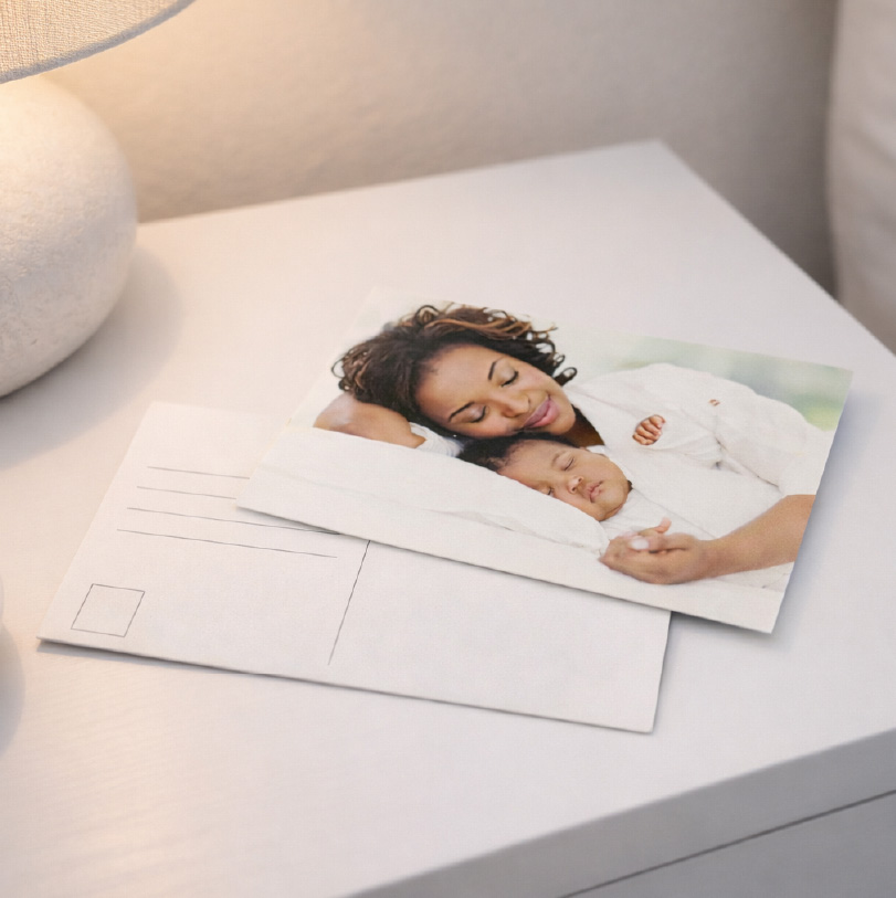 Postcard showing mother and baby sleeping peacefully together in a warm and intimate scene