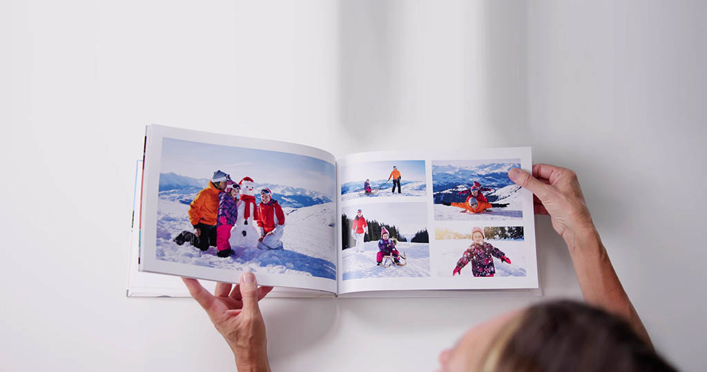 Woman Looking at Family Photo Album | Cherished Family Memories Woman viewing a family photo album filled with cherished family memories and special moments.