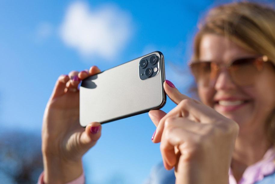 Woman Taking Photo with Smartphone | Capturing Everyday Moments Woman taking a photo with a smartphone, capturing special moments and memories.